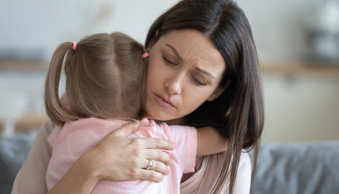 Worried Mother Embracing Daughter While Caring for a Terminally Ill Child