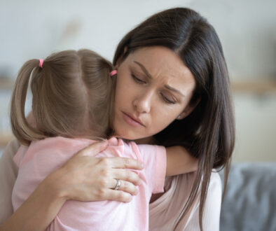 Worried Mother Embracing Daughter While Caring for a Terminally Ill Child