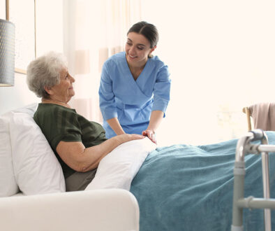 A Care Worker Adjusting The Bed Sheets For An Elderly Hospice Patient Difference Between Inpatient Hospice vs. Outpatient Hospice.