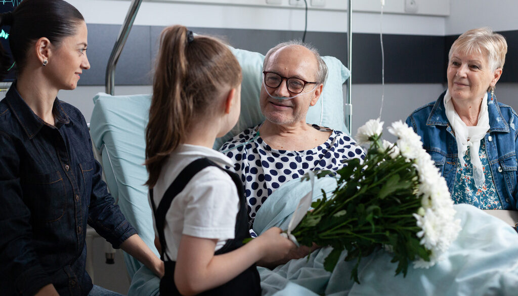 Little Girl With Her Mother Giving Flowers to an Elderly Loved One in Hospice Gifts for Hospice Patients