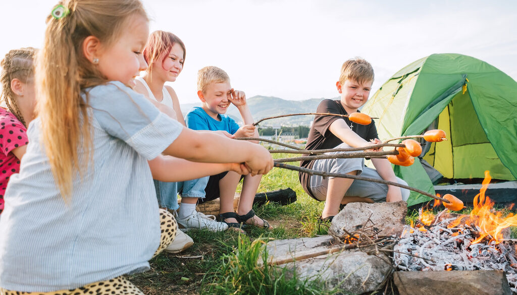 Kids at Wings Camp Roasting Hot Dogs Over a Campfire