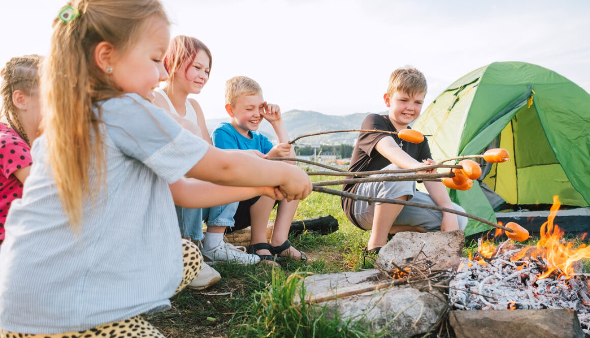 Kids at Wings Camp Roasting Hot Dogs Over a Campfire