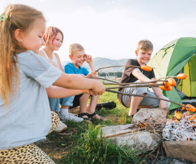 Kids at Wings Camp Roasting Hot Dogs Over a Campfire