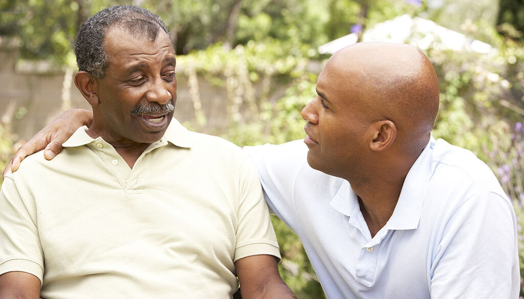 An African American Man With His Arm Around His Senior Dad’s Shoulder Having Serious End-Of-Life Conversations