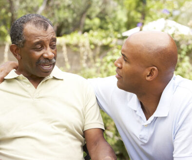 An African American Man With His Arm Around His Senior Dad’s Shoulder Having Serious End-Of-Life Conversations