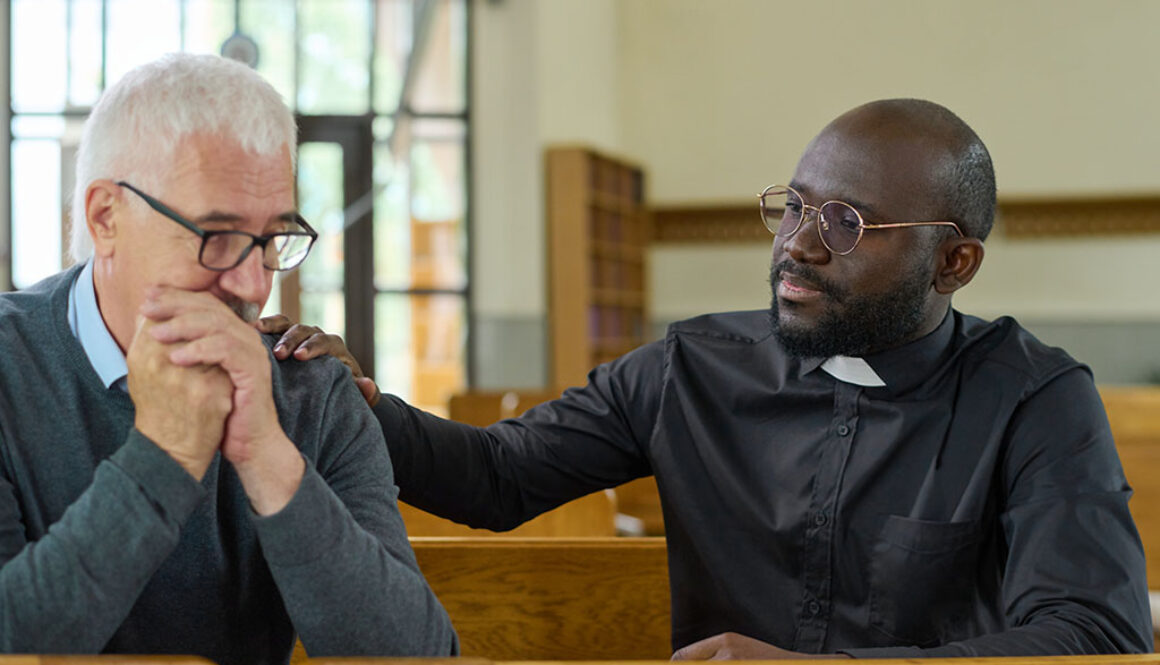 An African American Pastor With His Hand on an Older White Man’s Shoulder Providing Comfort Hospice Spiritual Care