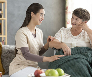 A Young Volunteering Caregiver Sitting Beside a Smiling Elderly Woman in a Wheelchair Is Hospice Volunteering Clinical