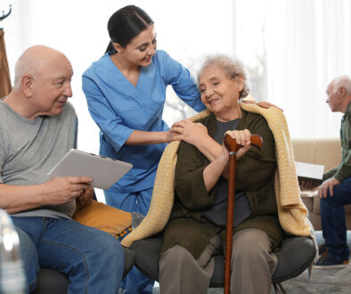 A Hospice Caregiver Wrapping a Blanket Around a Senior Woman in Hospice Care Non-profit vs For-Profit Hospice