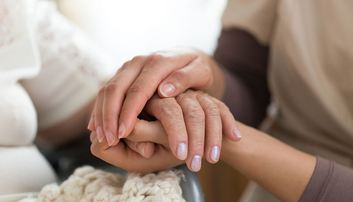 Close Up Of A Hospice Nurse Holding A Patient's Hand Providing Emotional Support For Hospice Patients
