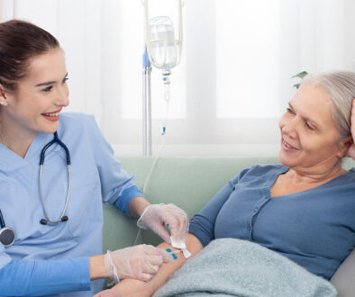 A Hospice Routine Home Care Nurse Inserting an IV Into A Senior Woman’s Arm